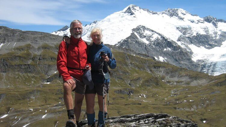 Richard Fox and a companion tramping in front of snow-capped mountains