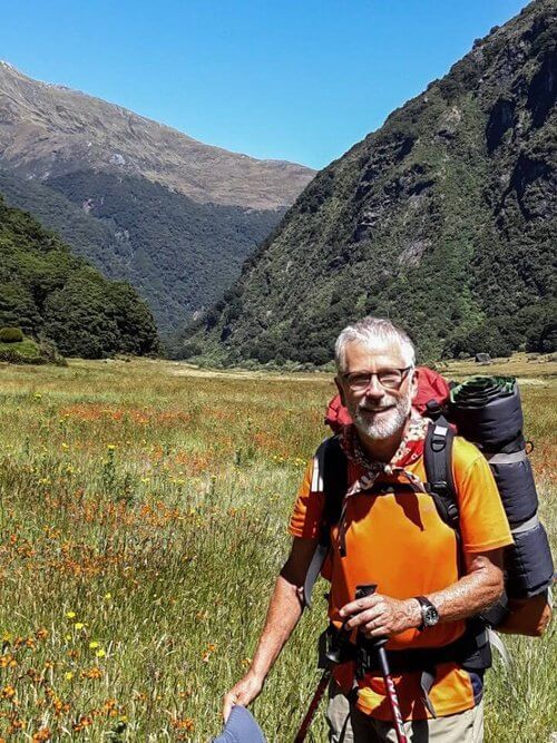 Richard Fox tramping with a pack in a mountain valley
